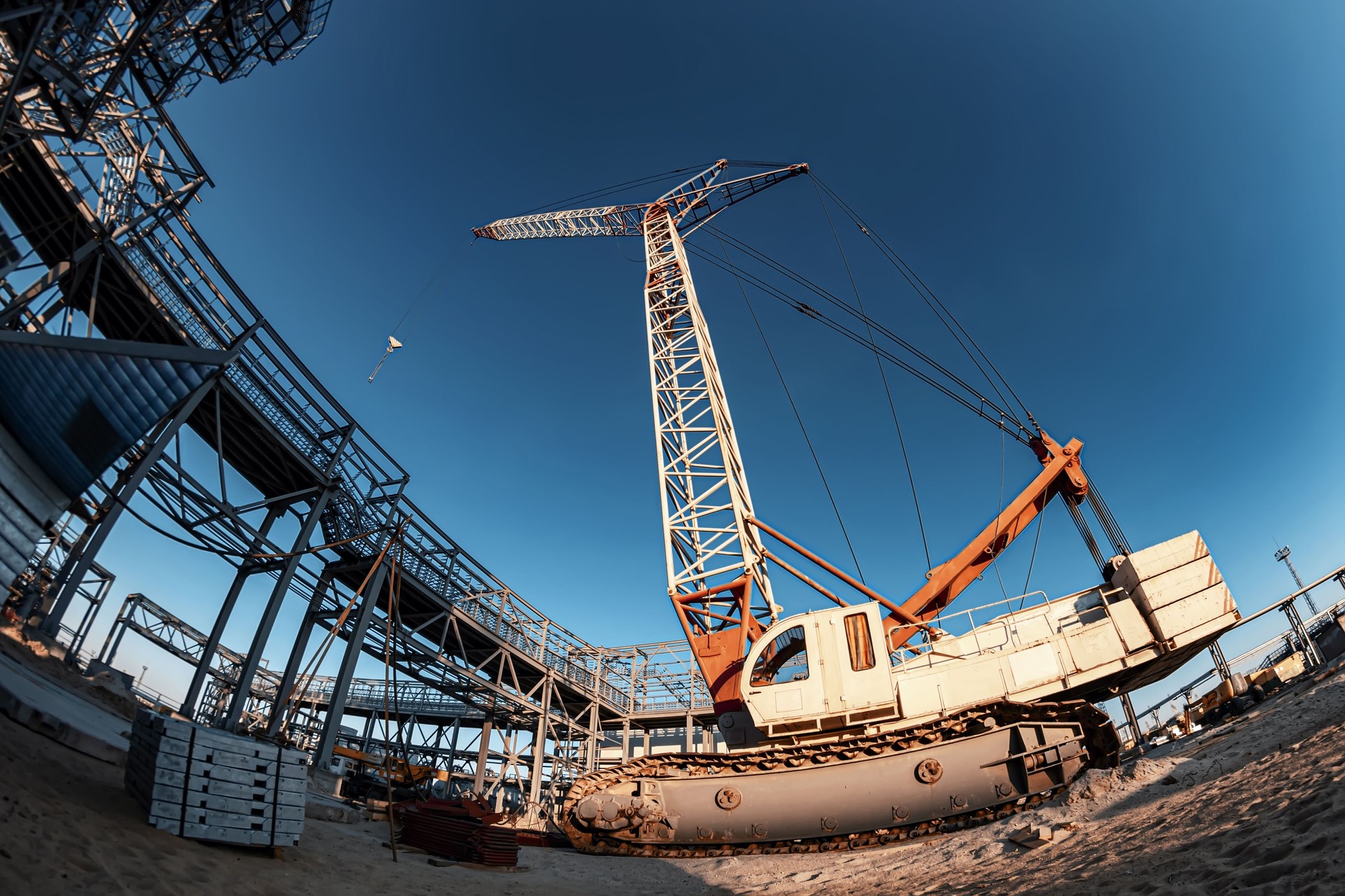 A self-propelled crawler crane stands on a construction site